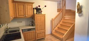 une cuisine avec des placards en bois et un escalier dans l'établissement Ferienwohnungen Haus Stierschneider, à Spitz