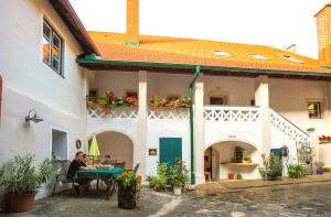 un homme assis à une table à l'extérieur d'un bâtiment dans l'établissement Ferienwohnungen Haus Stierschneider, à Spitz 15 autres photos