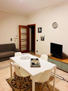Una sala de estar con una mesa y sillas blancas. en House in Cave, en Massafra