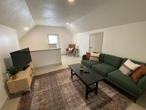a living room with a green couch and a table at Totally renovated large family getaway! King bed 
