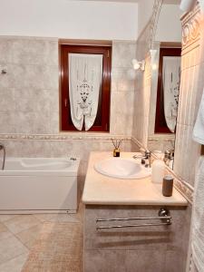 a bathroom with a tub and a sink and a bath tub at House in Cave - Casa Vacanze in Massafra