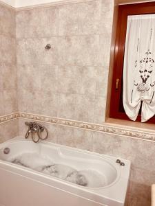 a white bath tub in a bathroom with a mirror at House in Cave - Casa Vacanze in Massafra