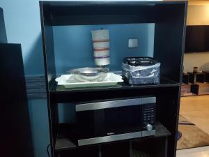 a microwave on a shelf with a bowl and other items at TwinVilleCove, affordable villas located in Ajah in Obalende +96 photos