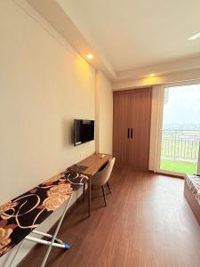 a room with a bed and a desk and a tv at paradise stay in Greater Noida