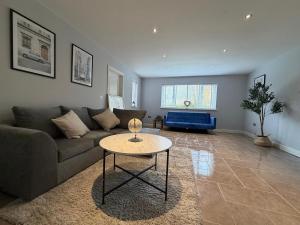 a living room with a couch and a table at Shenley House with Private Parking Central MK in Milton Keynes
