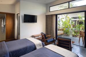 a hotel room with two beds and a balcony at Jaali Blue in Canacona +1 photo