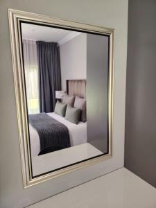 a mirror reflecting a bedroom with a bed in it at F'leur Guesthouse in Mokopane
