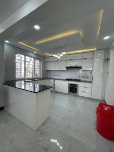 une cuisine avec des armoires blanches et un comptoir noir dans l'établissement Twin Paradise Homes, à Nairobi