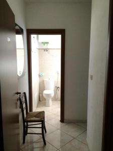a bathroom with a toilet and a chair in a room at Affittacamere CasaBattistini in Monti di Licciana Nardi +42 photos