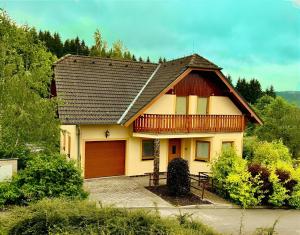 a yellow house with a brown garage at Villa Slupečná in Lipno nad Vltavou