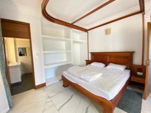 a bedroom with a bed with a wooden head board at Vipingo Luxury Villa in Kilifi