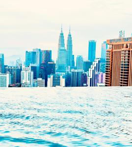 a view of a city skyline from the water at Lucentia Residence by Infinity swimming pool,lalaport KL in Kuala Lumpur