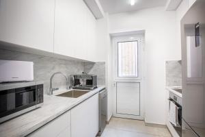 a kitchen with white cabinets and a sink and a window at Two Bedroom House In Town Center by Sweet Keys in Limassol +16 photos