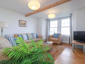 a living room with a couch and a tv at Tradewinds in Newquay