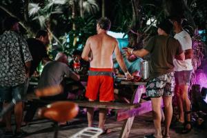 Un hombre sin camisa de pie junto a una mesa en una fiesta en Hostel Oryx Tulum, en Tulum 65 fotos más