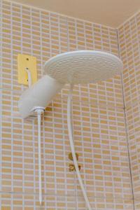 a white shower head hanging from a wall at Beira Mar e Frente Lagoa de Barra Velha 4 Quartos in Barra Velha