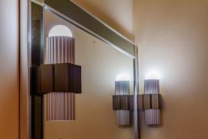 two lights on a mirror in a bathroom at Beira Mar e Frente Lagoa de Barra Velha 4 Quartos in Barra Velha