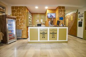 ロンダにあるオテル ビルゲン デ ロス レイエスの店のカウンターに座る女