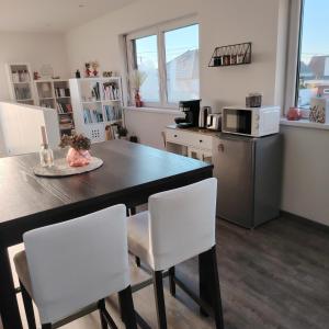 a kitchen with a table and chairs and a microwave at Au Chat l'Heureux in Mackenheim