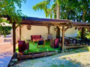 a pergola with chairs and a table in a yard at Casa dintre Brazi Colibita in Colibiţa