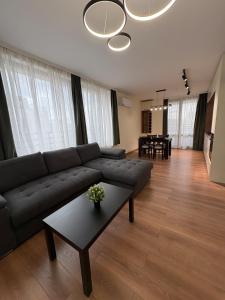 a living room with a couch and a table at New Urban Stay Airport city center metro access in Sofia