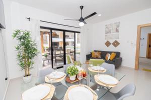 a living room with a glass table and chairs at Cozy 1-BR Apartment in Bayahibe in San Rafael del Yuma