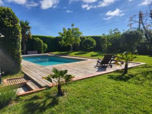 a backyard with a wooden deck and a swimming pool at Gîte du Ligal in Najac