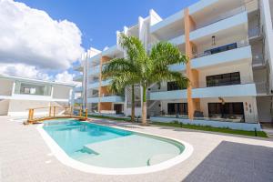 a swimming pool in front of a building at Cozy 1-BR Apartment in Bayahibe in San Rafael del Yuma