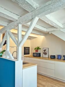 a kitchen with white cabinets and a wooden ceiling at Grand Verdière in La Rochelle +61 photos