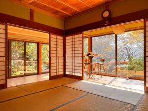 een lege kamer met een kamer met Japanse muren en ramen bij YUFUNOMORI Private and Suite in Yufu