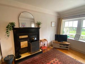 ein Wohnzimmer mit Kamin und Fernseher in der Unterkunft The Nuttings Cottage in Crail + 3 Fotos