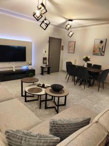 a living room with a couch and tables and a television at Faros & Beach View in Alexandroupoli