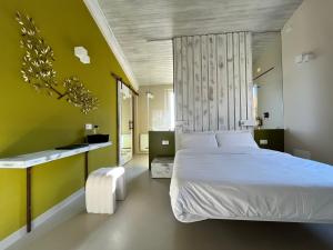a bedroom with a white bed and a green wall at Agriboutique L'Uliveto Magico in Cannara