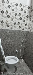 蒂鲁瓦纳马莱Sri Arunachala Rooms的浴室里有马桶和绣着花的帘子