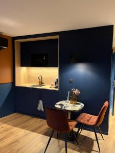 a kitchen with a table and chairs and a sink at Studios et Appartement meublé de tourisme in Altkirch +15 photos