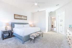 ein weißes Schlafzimmer mit einem Bett und einem Tisch in der Unterkunft Vitamin Sea in Inlet Beach