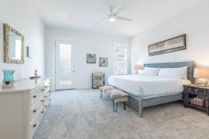 ein weißes Schlafzimmer mit einem großen Bett und einer Kommode in der Unterkunft Vitamin Sea in Inlet Beach