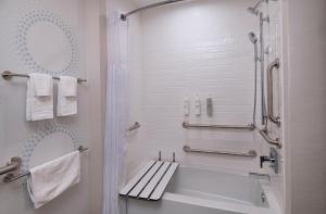 a bathroom with a shower and a bench in it at Tru By Hilton Irving Dfw South in Irving +28 photos