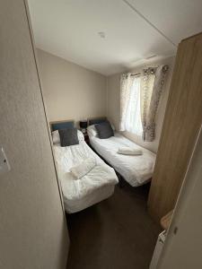 a small room with two beds and a window at Poppy Lodge LE 17 Ocean's Edge Park in Morecambe