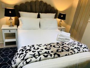 een bed met een zwart-wit dekbed en 2 lampen bij Tranquil Retreat in Durban
