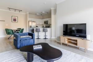 ein Wohnzimmer mit einem großen TV und einem blauen Stuhl in der Unterkunft Blueground Santa Clara pool nr Central Park SFO-2067 in Agnew