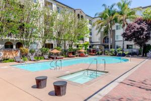 einen Pool in einem Innenhof mit Bäumen und Gebäuden in der Unterkunft Blueground Santa Clara pool nr Central Park SFO-2067 in Agnew