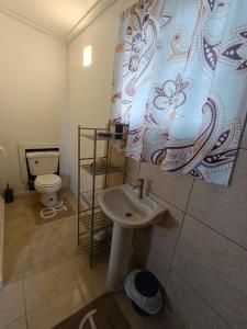 a bathroom with a sink and a toilet and a shower curtain at cabanita Celeste in Boca Chica
