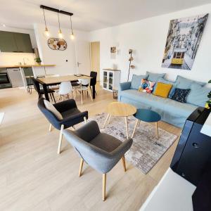 a living room with a blue couch and a table at Élégant appartement lumineux à Senlis in Senlis
