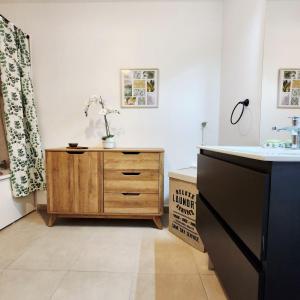 a bathroom with a sink and a wooden dresser at Élégant appartement lumineux à Senlis in Senlis