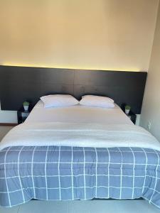 a large bed with two pillows on top of it at Casa com 3 suítes em bairro nobre in São Lourenço +22 photos