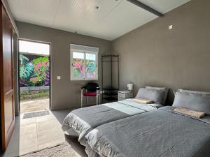 a bedroom with a bed and a desk and a window at Fathill Finca in Tamaide