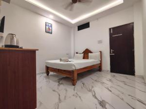 a bedroom with a bed and a wooden door at The Hotel Eden Beach in Puducherry