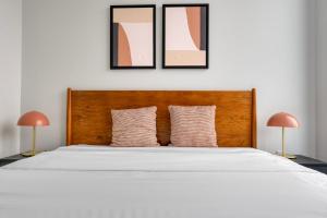 a bedroom with a large white bed with two lamps at Blueground Downtown Austin pool nr Texas State Capitol ATX-238 in Austin +30 photos