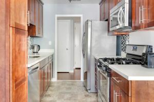 レッドウッドシティにあるBlueground Edgewood Park pool nr Edgewood Park SFO-2073のキッチン(木製キャビネット、ステンレス製の冷蔵庫付)